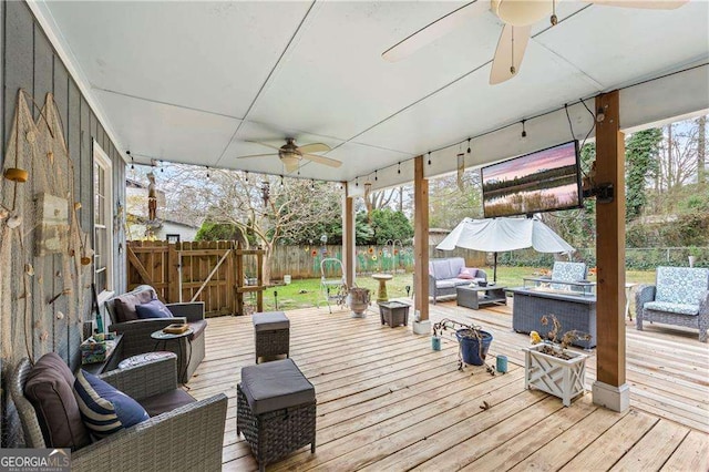 wooden deck with an outdoor living space with a fire pit, a fenced backyard, and a ceiling fan