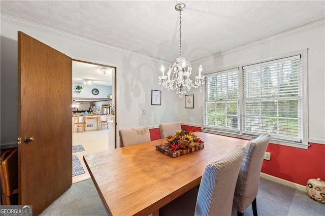 dining area featuring baseboards, carpet floors, an inviting chandelier, a textured ceiling, and crown molding