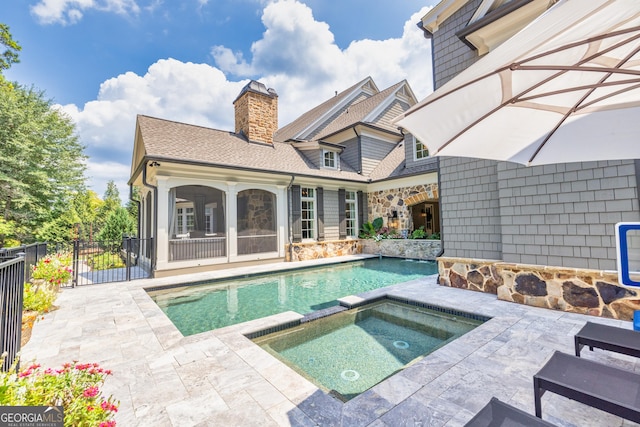 view of swimming pool with a patio, fence, a fenced in pool, and an in ground hot tub