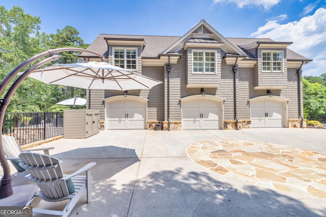 view of front of home with a garage, fence, a shingled roof, and driveway