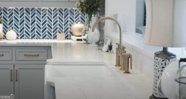 room details with light stone counters and a sink