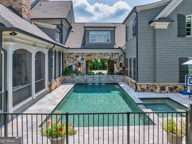 view of swimming pool with a patio and a pool with connected hot tub