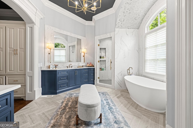 bathroom with an inviting chandelier, a freestanding tub, vanity, a stall shower, and crown molding