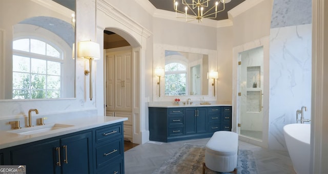 bathroom with a soaking tub, a sink, two vanities, ornamental molding, and a notable chandelier