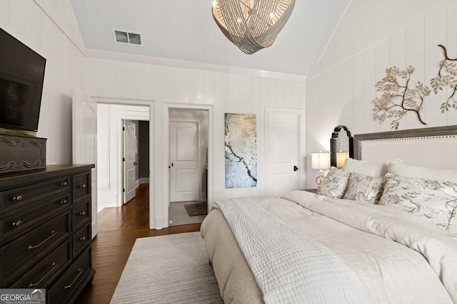 bedroom with high vaulted ceiling, visible vents, dark wood-style flooring, and a decorative wall