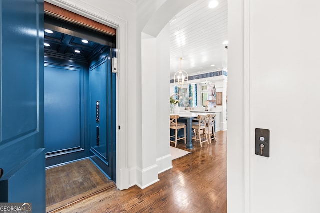 hall featuring recessed lighting, arched walkways, elevator, ornamental molding, and dark wood-style floors