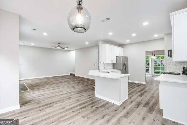 kitchen featuring a sink, tasteful backsplash, white cabinets, and stainless steel refrigerator with ice dispenser