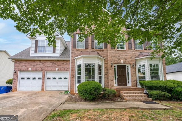 view of front of house with brick siding, roof with shingles, and driveway