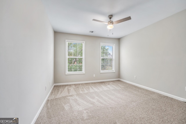 empty room featuring visible vents, carpet floors, and baseboards