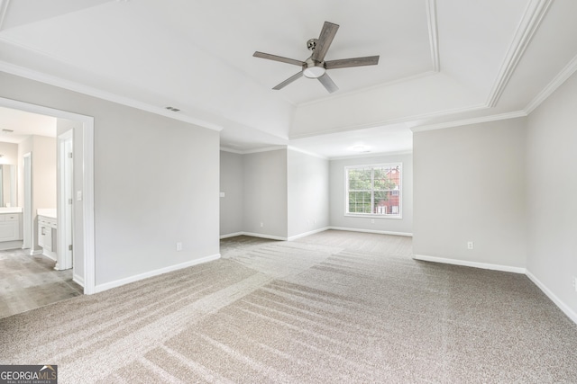 spare room featuring carpet flooring, baseboards, crown molding, and a tray ceiling