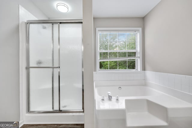 full bath with a stall shower and a garden tub