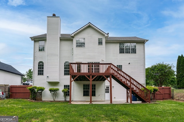 rear view of property featuring a patio, fence, a yard, stairway, and a chimney