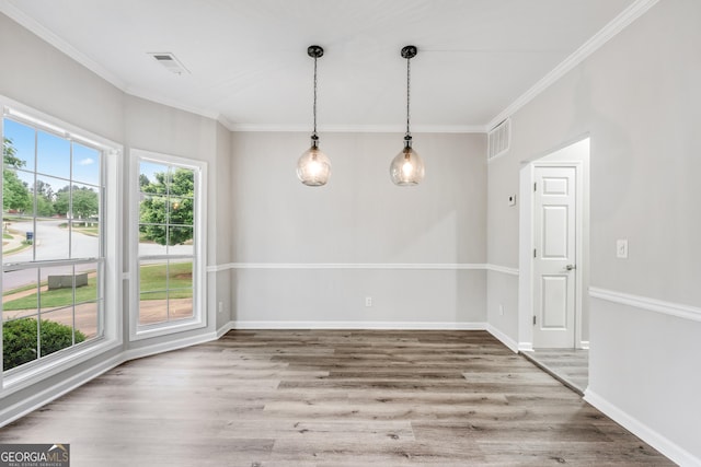 spare room with crown molding, wood finished floors, and visible vents