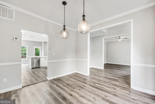 unfurnished dining area featuring a ceiling fan, baseboards, visible vents, crown molding, and light wood-type flooring