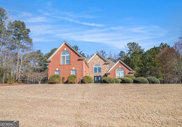 traditional home with brick siding and a front yard