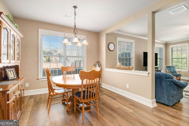 dining area with an inviting chandelier, baseboards, visible vents, and light wood finished floors