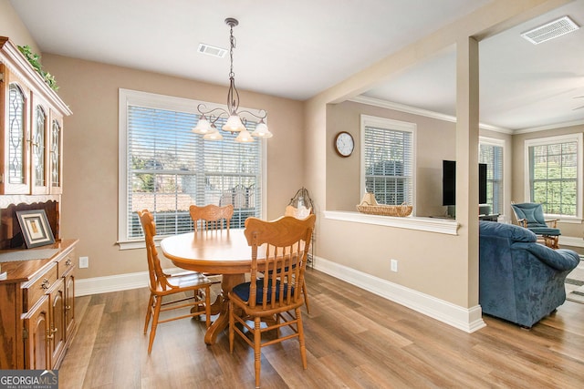 dining room featuring light wood-type flooring, visible vents, baseboards, and an inviting chandelier