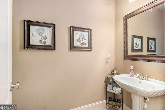 bathroom featuring baseboards and a sink