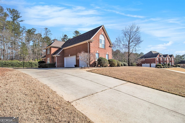 view of side of property with brick siding, a lawn, and concrete driveway