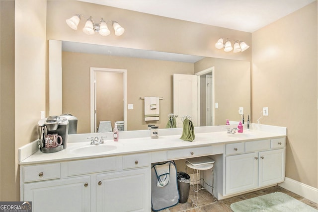 bathroom featuring baseboards, tile patterned floors, a sink, and double vanity