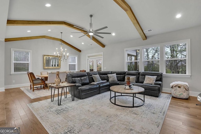 living room featuring a wealth of natural light, lofted ceiling with beams, and hardwood / wood-style flooring