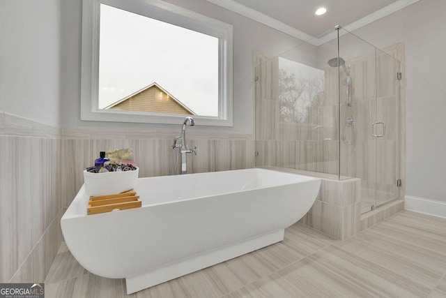 full bath featuring a wainscoted wall, ornamental molding, a sink, a shower stall, and a freestanding bath