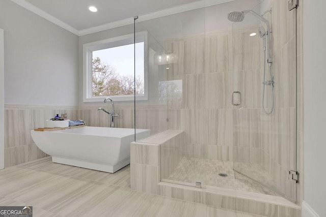 full bath with ornamental molding, wainscoting, a stall shower, and a freestanding bath