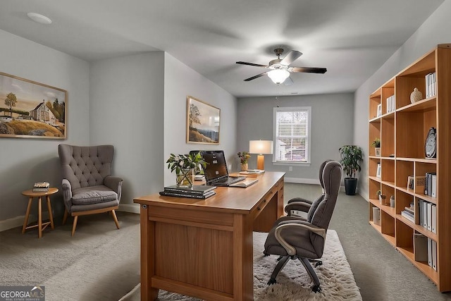 office space featuring ceiling fan, baseboards, and light carpet