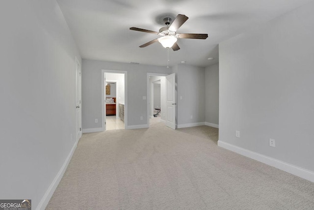 empty room featuring ceiling fan, visible vents, baseboards, and light carpet