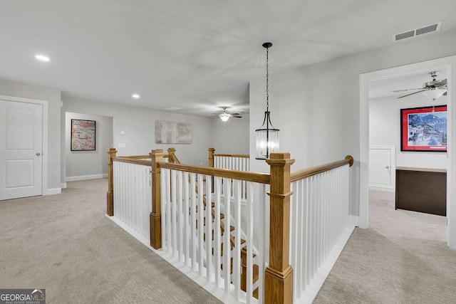 hallway with recessed lighting, visible vents, an upstairs landing, and carpet flooring