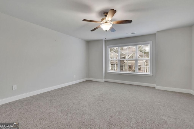 empty room with light carpet, visible vents, ceiling fan, and baseboards