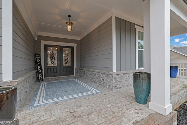 property entrance with brick siding, french doors, and a porch