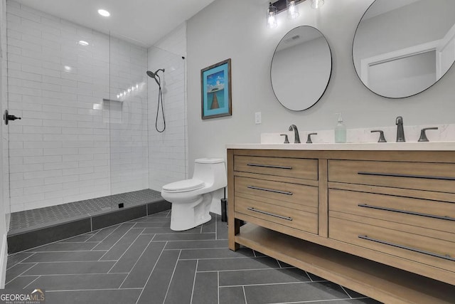 full bath featuring a sink, tiled shower, toilet, and tile patterned flooring