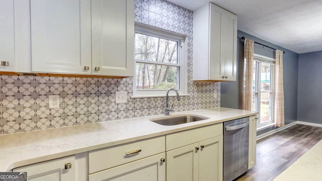 kitchen with a wealth of natural light, decorative backsplash, stainless steel dishwasher, and a sink