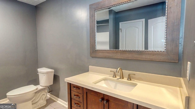 bathroom featuring tile patterned flooring, toilet, vanity, and baseboards