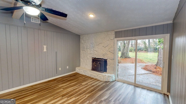 unfurnished living room featuring vaulted ceiling, visible vents, a textured ceiling, and wood finished floors