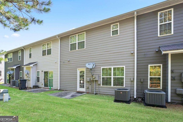 rear view of house featuring a lawn and central air condition unit