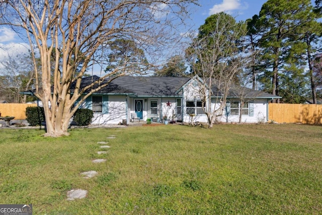 ranch-style home featuring a front lawn and fence