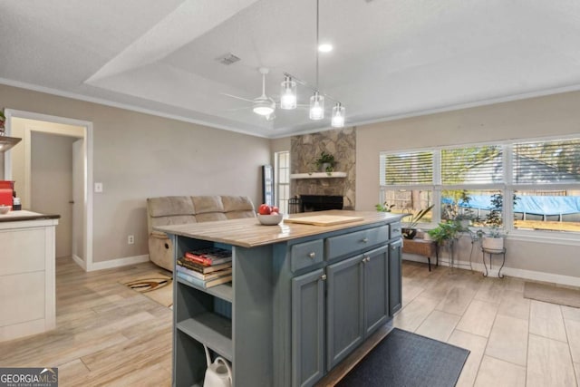 kitchen featuring ornamental molding, open shelves, open floor plan, light wood finished floors, and ceiling fan