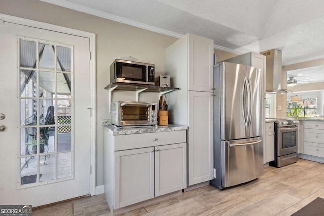 kitchen featuring crown molding, a toaster, island exhaust hood, light wood-style floors, and stainless steel appliances