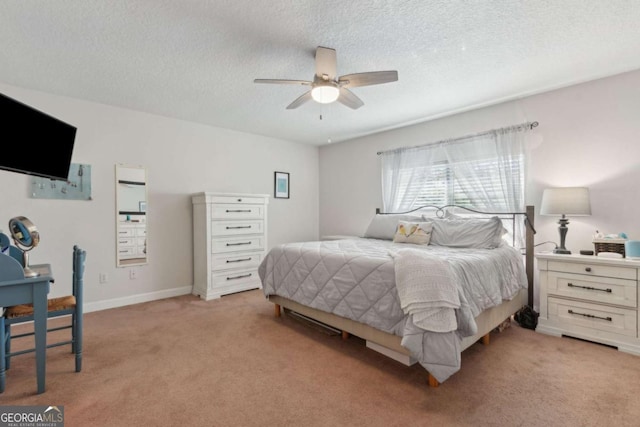 bedroom featuring light carpet, ceiling fan, a textured ceiling, and baseboards