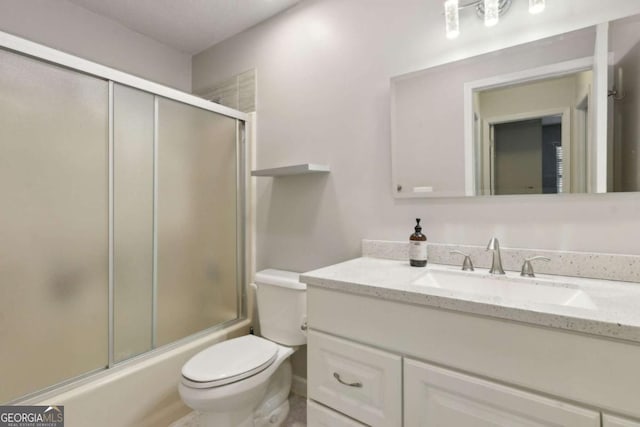 full bathroom featuring toilet, vanity, and shower / bath combination with glass door