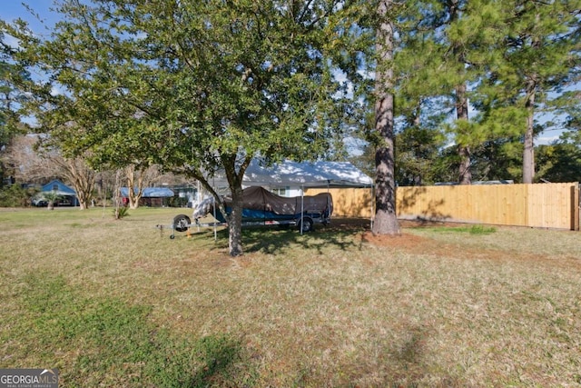 view of yard featuring a trampoline and fence