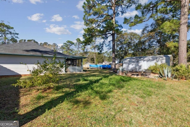 view of yard with a storage shed, an outdoor structure, and a sunroom