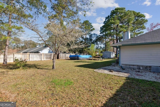 view of yard featuring a swimming pool and fence