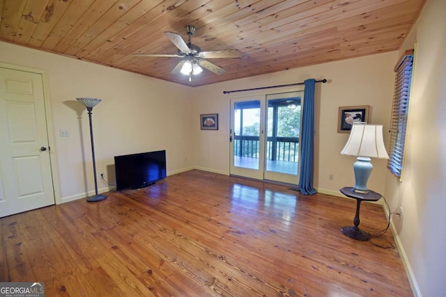 unfurnished living room featuring hardwood / wood-style flooring, baseboards, and wooden ceiling