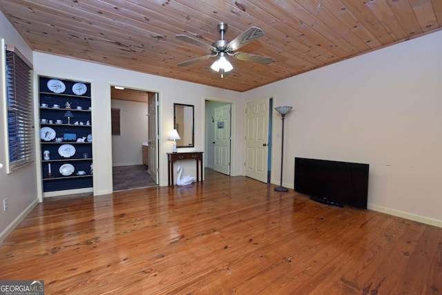 unfurnished living room featuring hardwood / wood-style flooring, built in features, baseboards, and wooden ceiling