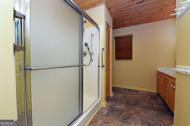 full bathroom with a shower stall, baseboards, wood ceiling, stone finish floor, and vanity