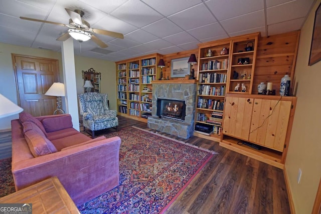 living room with a fireplace, a paneled ceiling, ceiling fan, and wood finished floors