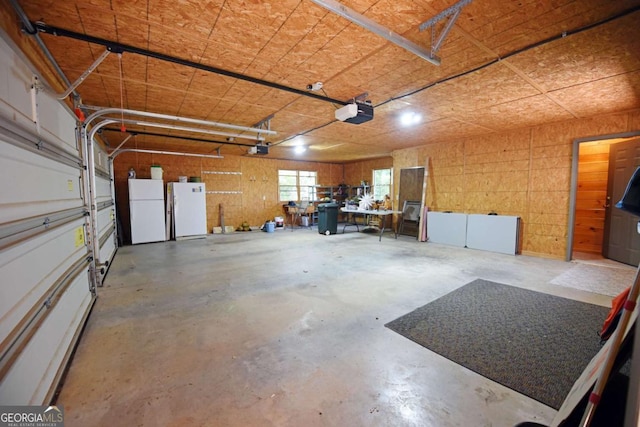 garage featuring a garage door opener and freestanding refrigerator